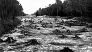 Das schwarzweiß Foto zeigt eine gerodete Autobahntrasse nach dem Mutterbodenabtrag. 